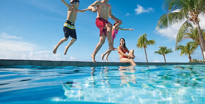 Three kids jumping in pool