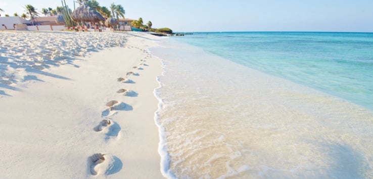 Footprints in the sand near water in Aruba