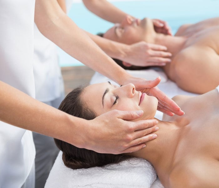 couple enjoying massage poolside at the spa