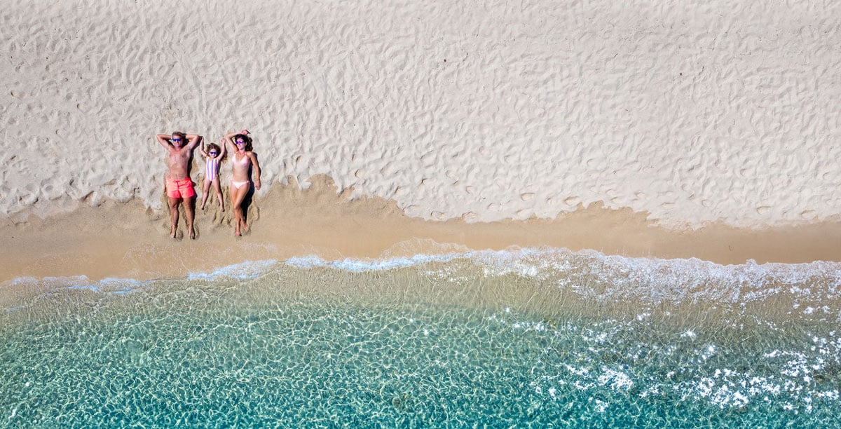 Family laying in the sand along beach shore