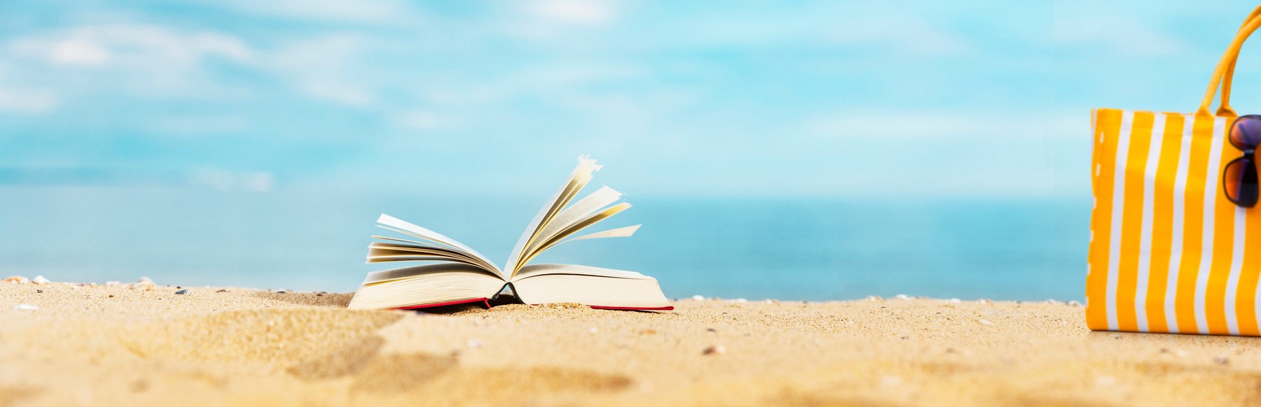 Book resting in the sand at the beach